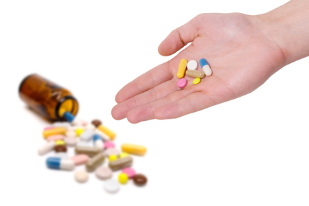 Medicine pills in hand on a white backgroundの写真素材