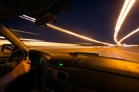 Car speed night drive on the road in cityの写真素材