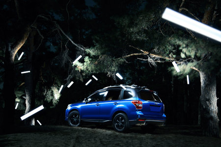 Saratov, Russia - September 28, 2015: Car Subaru Forester stand in forest, concept lights at nightのeditorial素材