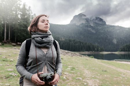 Woman traveler with vintage camera at beautiful nature landscapeの写真素材