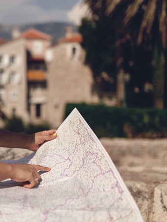 Woman traveler with map in old town at daytimeの写真素材