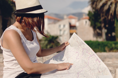 Woman traveler with map in old town at daytimeの写真素材