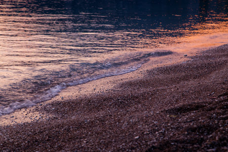 Beautiful golden orange sunset at sea pebble beach