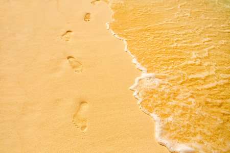 Footprints on the tropical beach at daytimeの写真素材