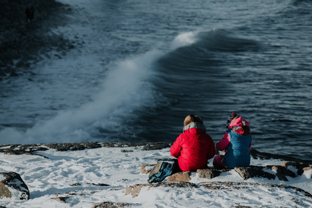 Couple is sitting at mountain peak near Arctic Ocean coastlineの写真素材