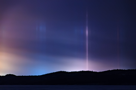 Light pillar hallo effect in atmosphere at nightの写真素材