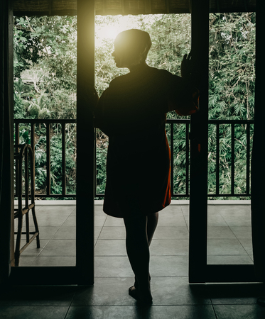 Silhouette of beautiful woman in entrance near tropical forestの写真素材
