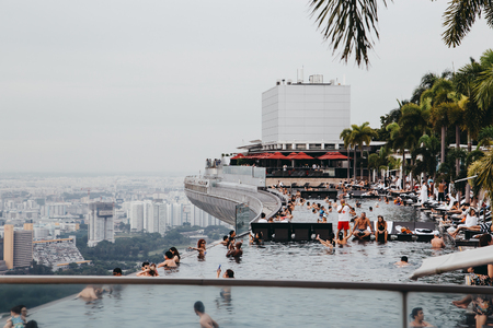 Singapore, Singapore - October 16, 2017: Viewpoint from infinity swimming pool of Marina Bay Sands hotel. Downtown landscape at golden sunsetのeditorial素材