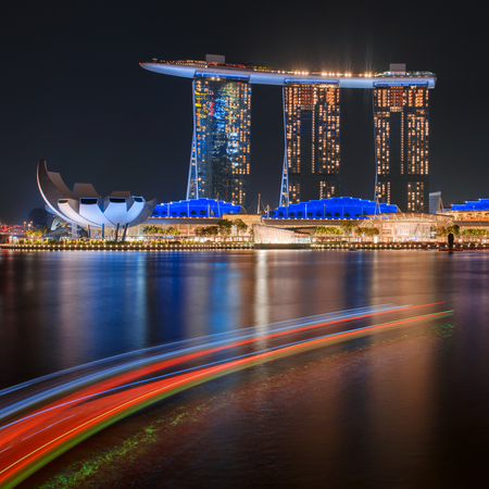 Famous landmark Marina Bay Sands hotel reflected in water. Illuminated at night. Singapore cityのeditorial素材