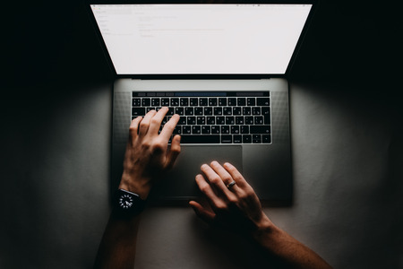 Man is working typing use laptop computer at dark night. Writer flat lay top view workplaceの写真素材