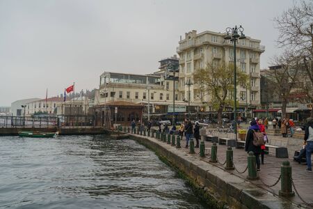 Istanbul, Turkey - December 17, 2018: Local people are walking at seafront at Ortakoy district in Istanbul, Turkey. Dramatic rainy skyのeditorial素材