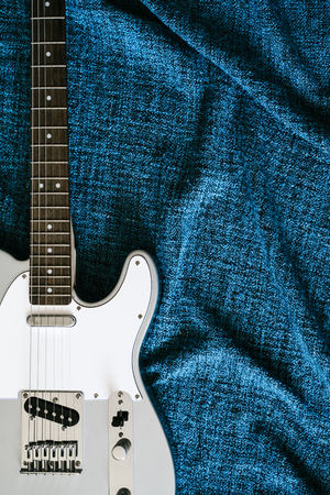 Guitar electric. Rock music background. Top view on blue textile clothの写真素材