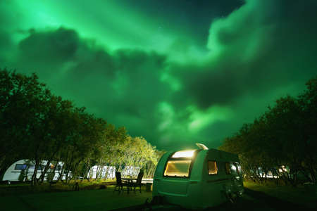 Caravan camp trailers on the camping at night. Northern Lights (Aurora Borealis) in the skyの写真素材
