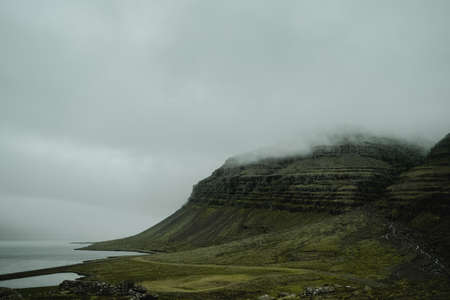 Beautiful nature dramatic landscape in Iceland. Low clouds, fog on the mountains. Cold toned filterの写真素材