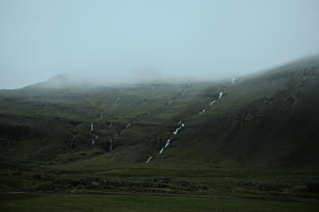 Beautiful nature dramatic landscape in Iceland. Low clouds, fog on the mountains. Cold toned filterの写真素材