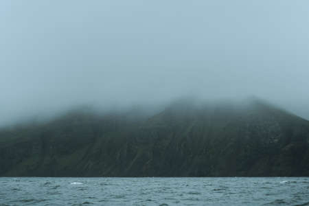 Beautiful nature dramatic landscape in Iceland. Low clouds, fog on the mountains. Cold toned filterの写真素材