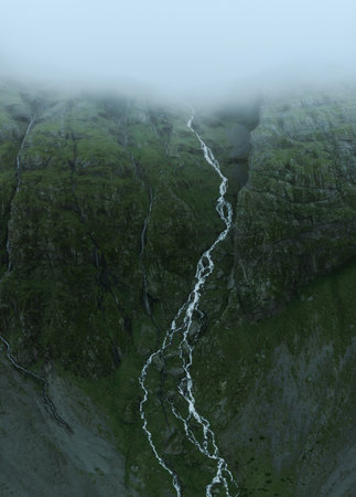 Beautiful nature dramatic landscape in Iceland. Low clouds, fog on the mountains. Cold toned filterの写真素材