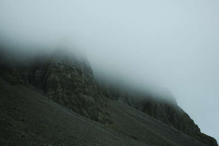 Beautiful nature dramatic landscape in Iceland. Low clouds, fog on the mountains. Cold toned filterの写真素材