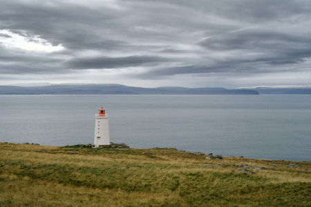 Lighthouse on the cliff near the ocean in Northwest Icelandの写真素材