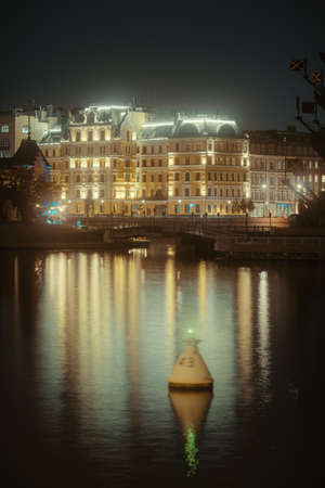 Illuminated building reflected in the water in city center Moscow, Russia at nightの写真素材