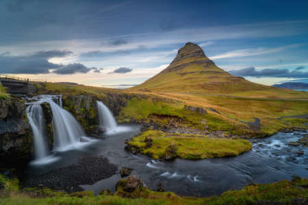 Western Iceland landscape. Kirkjufell mountain and Kirkjufellsfoss waterfall at beautiful sunset. Famous icelandic nature view, located at Snaefellsnes (SnÃ¦fellsnes) peninsulaの写真素材