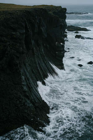 Western Iceland nature landscape. Basalt rock cliff in Snaefellsnes (SnÃ¦fellsnes) peninsula near Arnarstapi village. Stormy waves at rainy weatherの写真素材