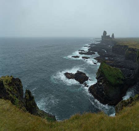 Western Iceland nature landscape. Basalt rock cliff Londrangar in Snaefellsnes (SnÃ¦fellsnes) peninsula. Stormy waves at rainy weatherの写真素材