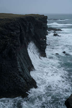 Western Iceland nature landscape. Basalt rock cliff in Snaefellsnes (SnÃ¦fellsnes) peninsula near Arnarstapi village. Stormy waves at rainy weatherの写真素材