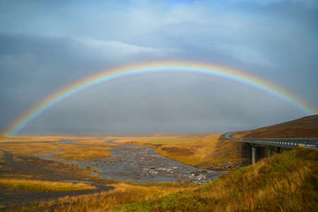 Panorama view of icelandic nature landscape. Rainbow after rain, road and river. West Iceland regionの写真素材