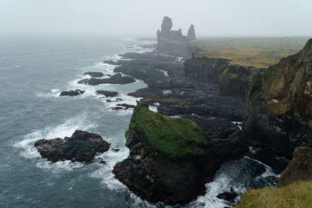 Western Iceland nature landscape. Basalt rock cliff Londrangar in Snaefellsnes (SnÃ¦fellsnes) peninsula. Stormy waves at rainy weatherの写真素材