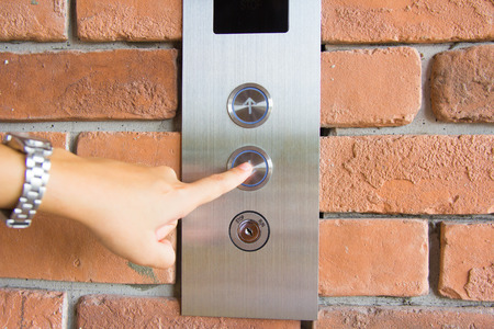 people  pressing elevator buttonの写真素材