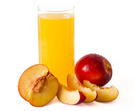 peach juice in glass with peaches around itの写真素材