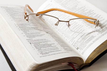 Holy Bible opened with glasses on it