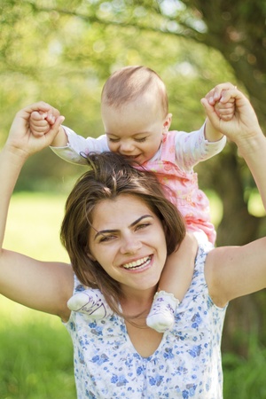 happy mother with her child on her shouldersの写真素材