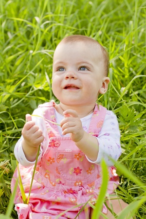 Happy baby girl on grassの写真素材