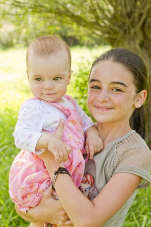 A teenage girl with a baby in armsの写真素材