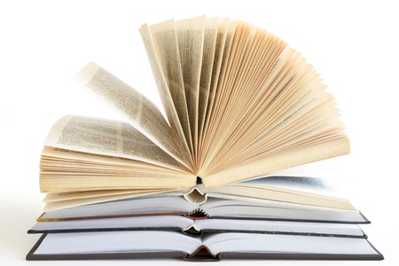 Stack of open old fanned hardcover leather bound booksの写真素材