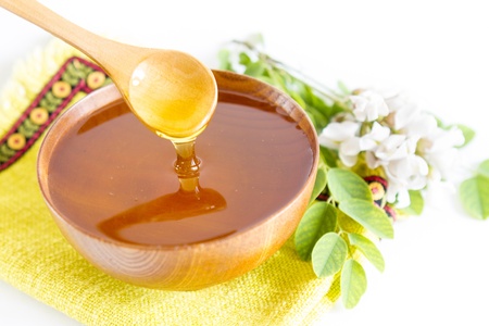 Honey in wooden bowl and acacia plantの写真素材