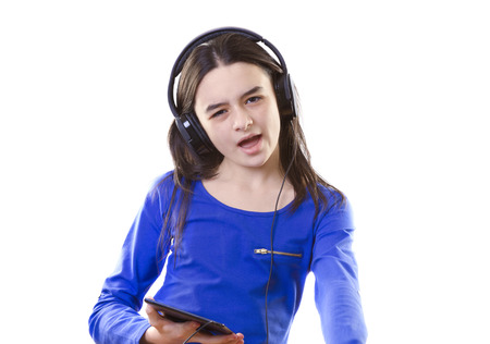 Smiling girl listening to music, holding a tablet pc in handsの写真素材