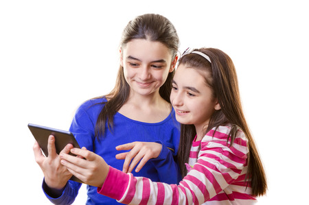 Happy teen girls with digital tablet  on white 
の写真素材