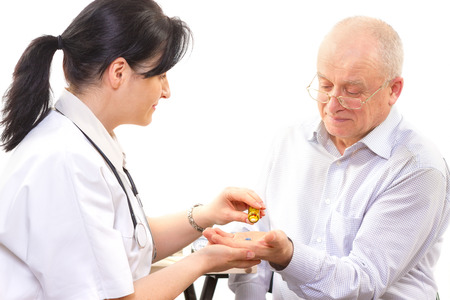 doctor giving the medicine to a senior man. focus on the pillsの写真素材