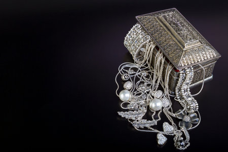 Silver jewelry on black background.