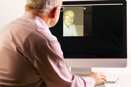 Man at computer on white backgroundの写真素材