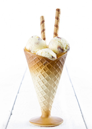 Vanilla ice cream  with wafer in cup on white wooden backgroundの写真素材