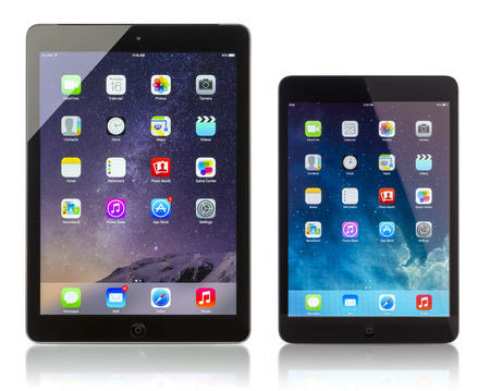 Apple iPad Air Wi-Fi + Cellular displaying iOS 8 and iPad Mini with iOS 7.1 homescreen. iOS 8  operating system designed by Apple Inc. official output 16 October 2014. iPad is a tablet produced by Apple Incのeditorial素材