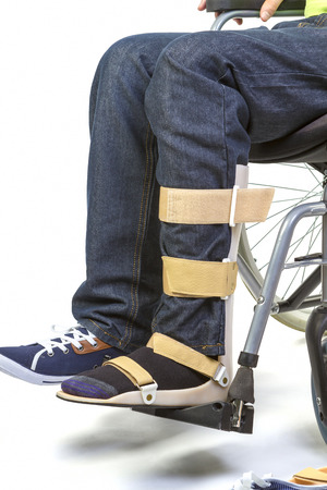 Orthopedist puts orthosis to patient in wheelchair with disabilitiesの写真素材