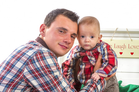 Baby boy with his father on white backgroundの写真素材