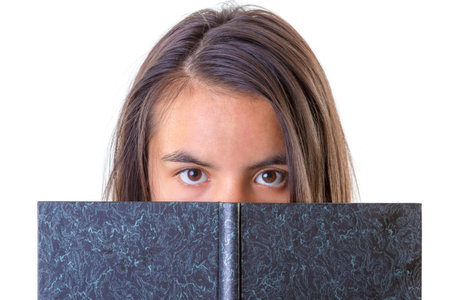 closeup portrait of cute brunette with book on white backgroundの写真素材