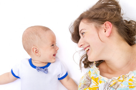mother talks with her baby boy on withe backgroundの写真素材