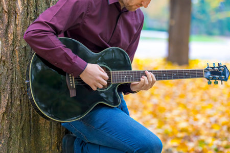Close up person man's hands playing acoustic guitar artist musician. Focus on fingers.
